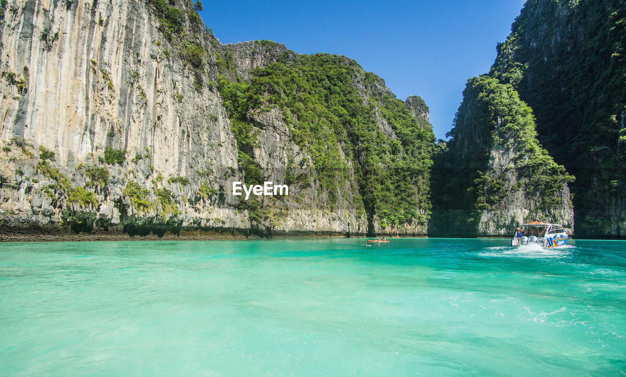 SCENIC VIEW OF SEA AND ROCKS AGAINST CLEAR BLUE SKY