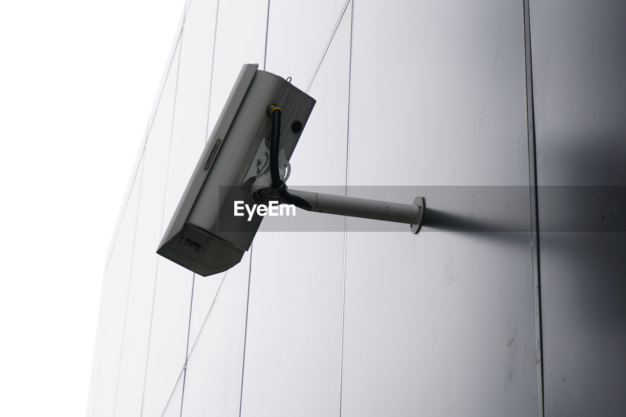 Low angle view of security camera on wall