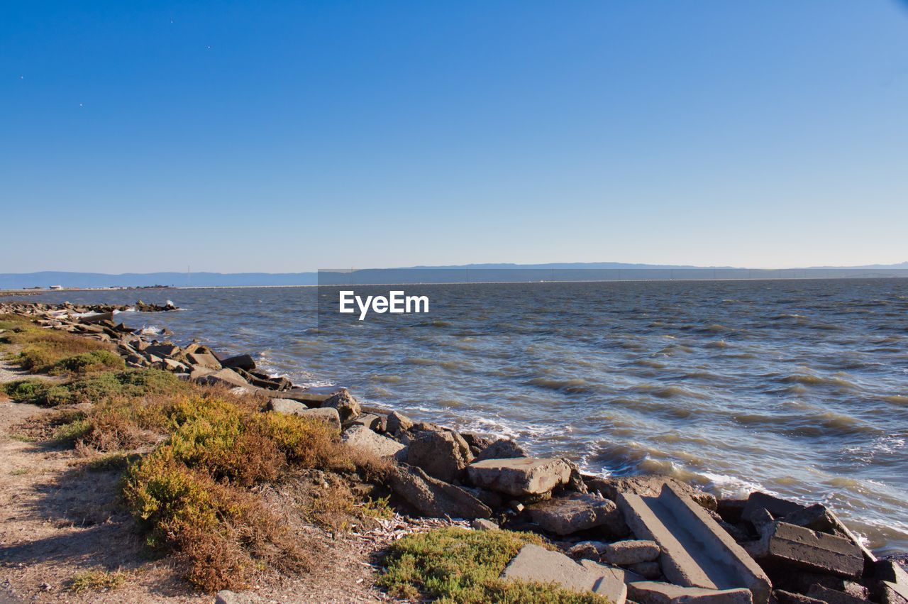 Scenic view of sea against clear blue sky