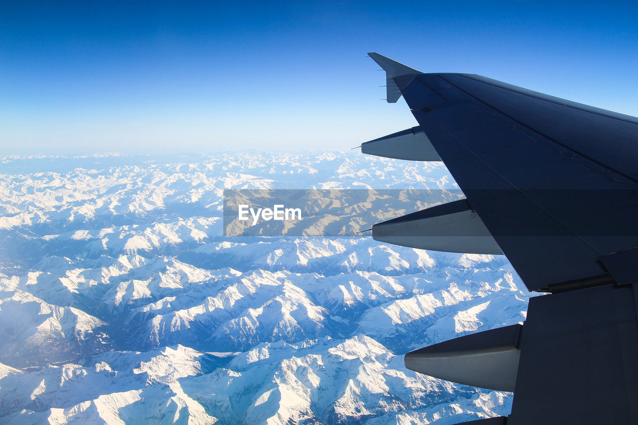AERIAL VIEW OF AIRPLANE WING OVER SNOW LANDSCAPE