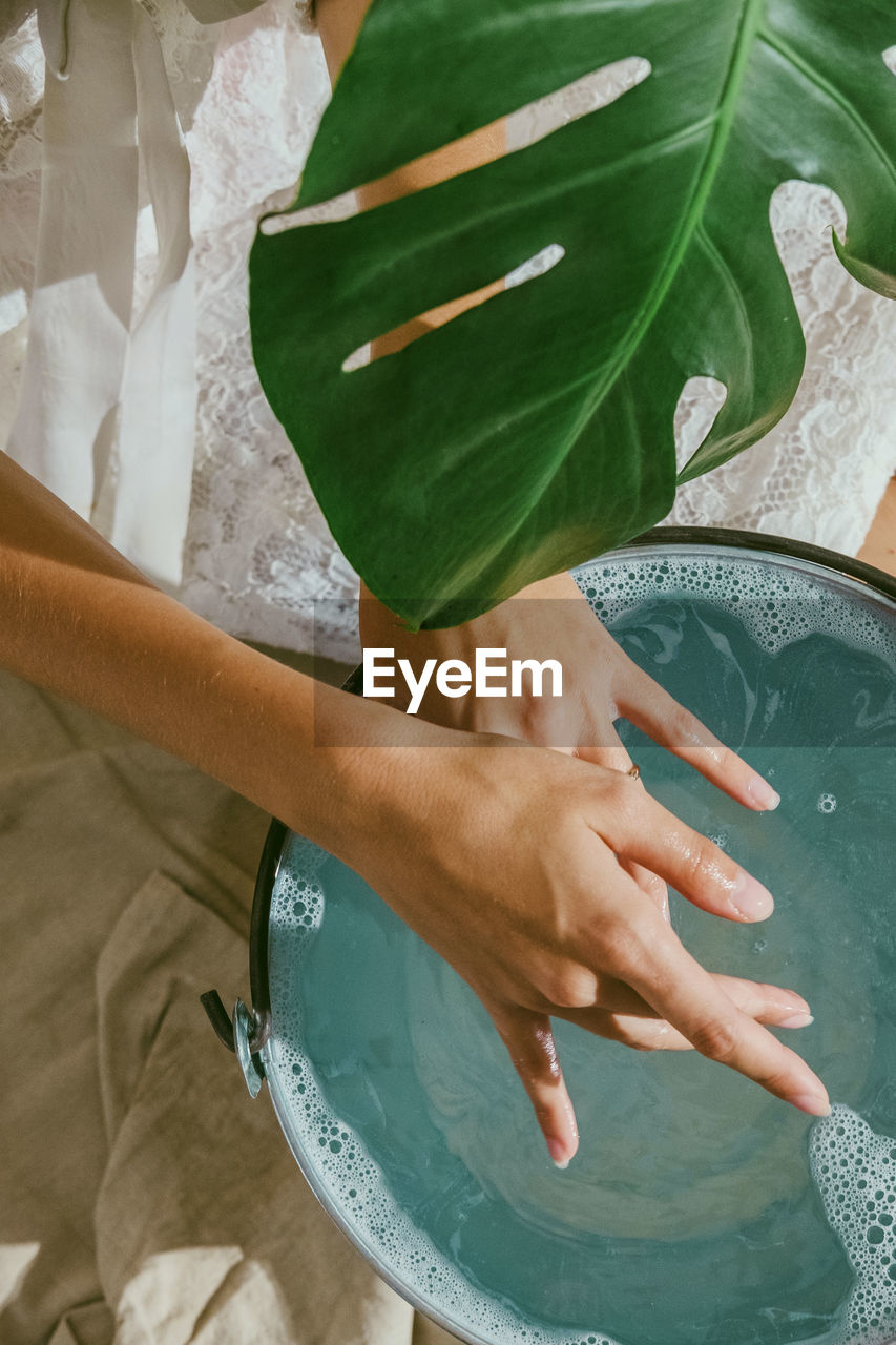 Midsection of woman cleaning hands in water