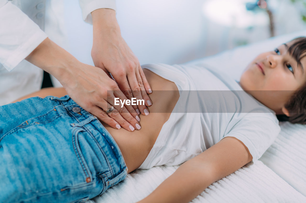 Pediatrician gastroenterologist, examining preschooler boys abdomen.