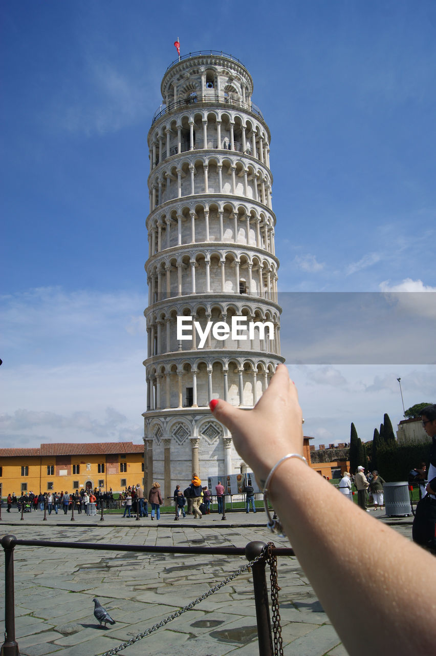 Optical illusion of woman holding leaning tower of pisa