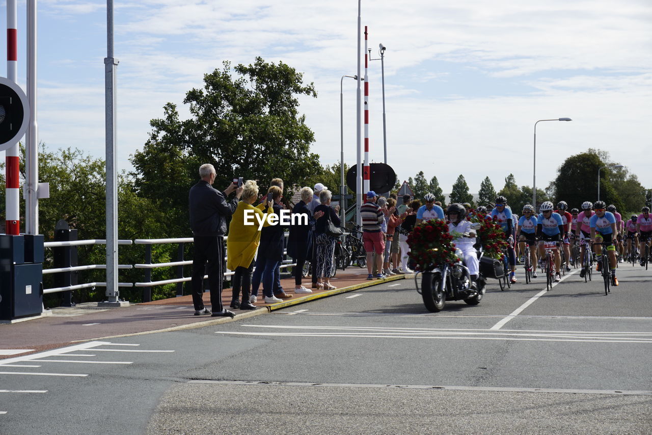 PEOPLE ON ROAD AGAINST SKY