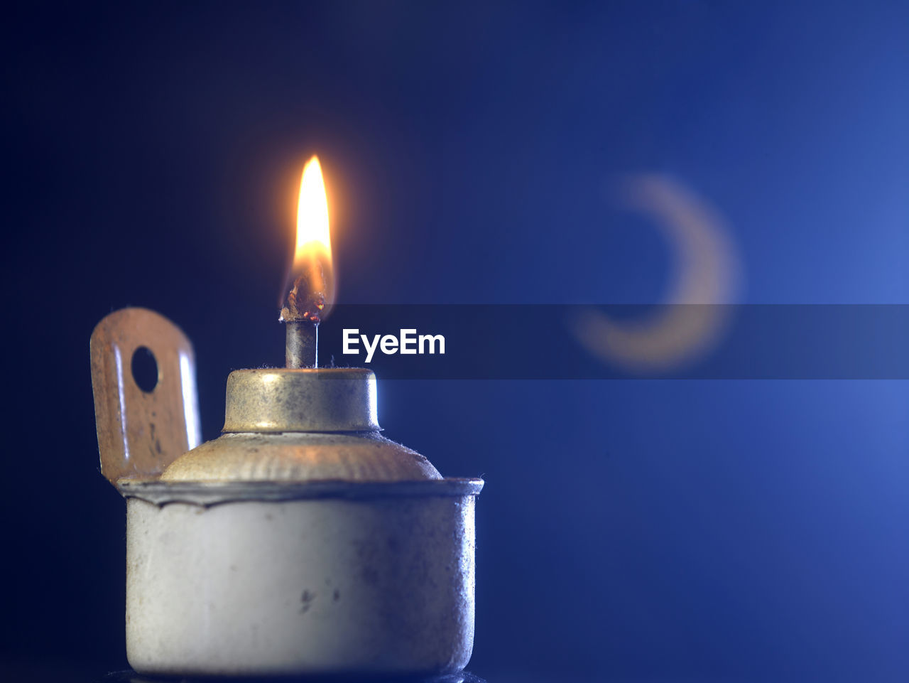 Oil lamp with crescent on the blue background