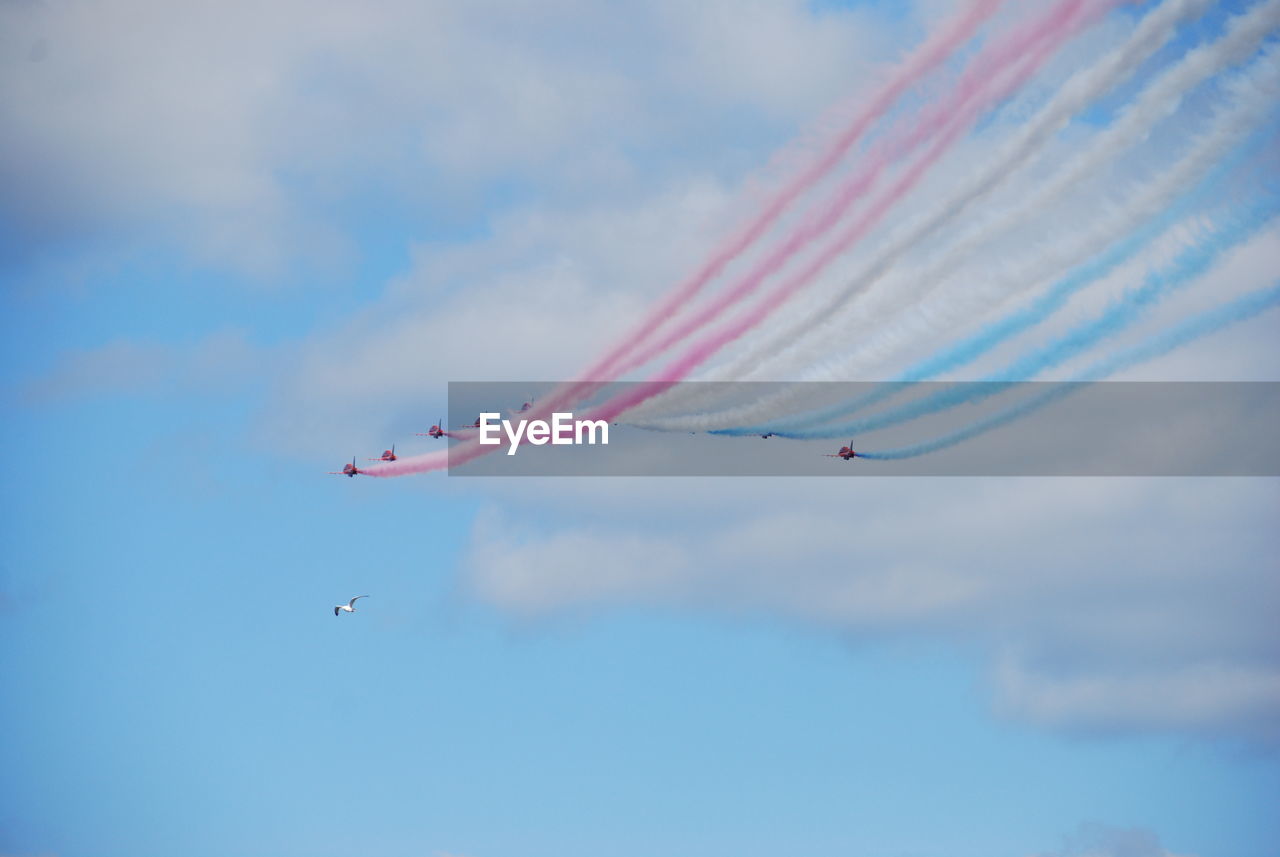 Low angle view of fighter planes performing airshow in sky