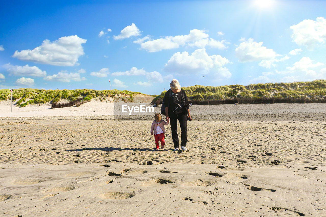 Full length of couple walking on beach