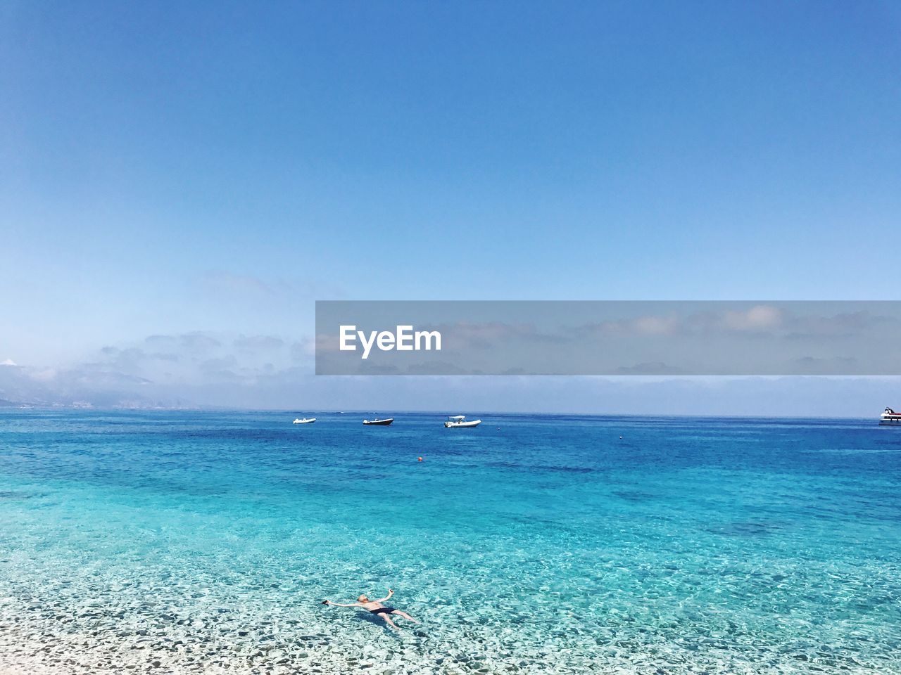 Scenic view of sea against clear blue sky