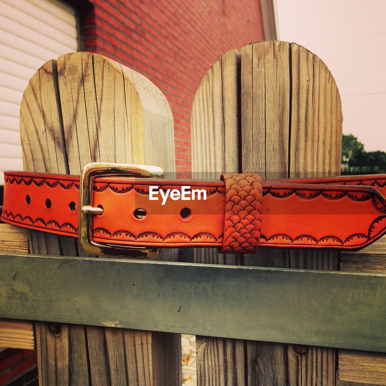 Close-up of orange belt on wooden fence