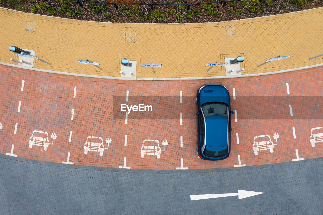 Aerial view directly above  electric vehicle charging station with parking spaces for charging bays