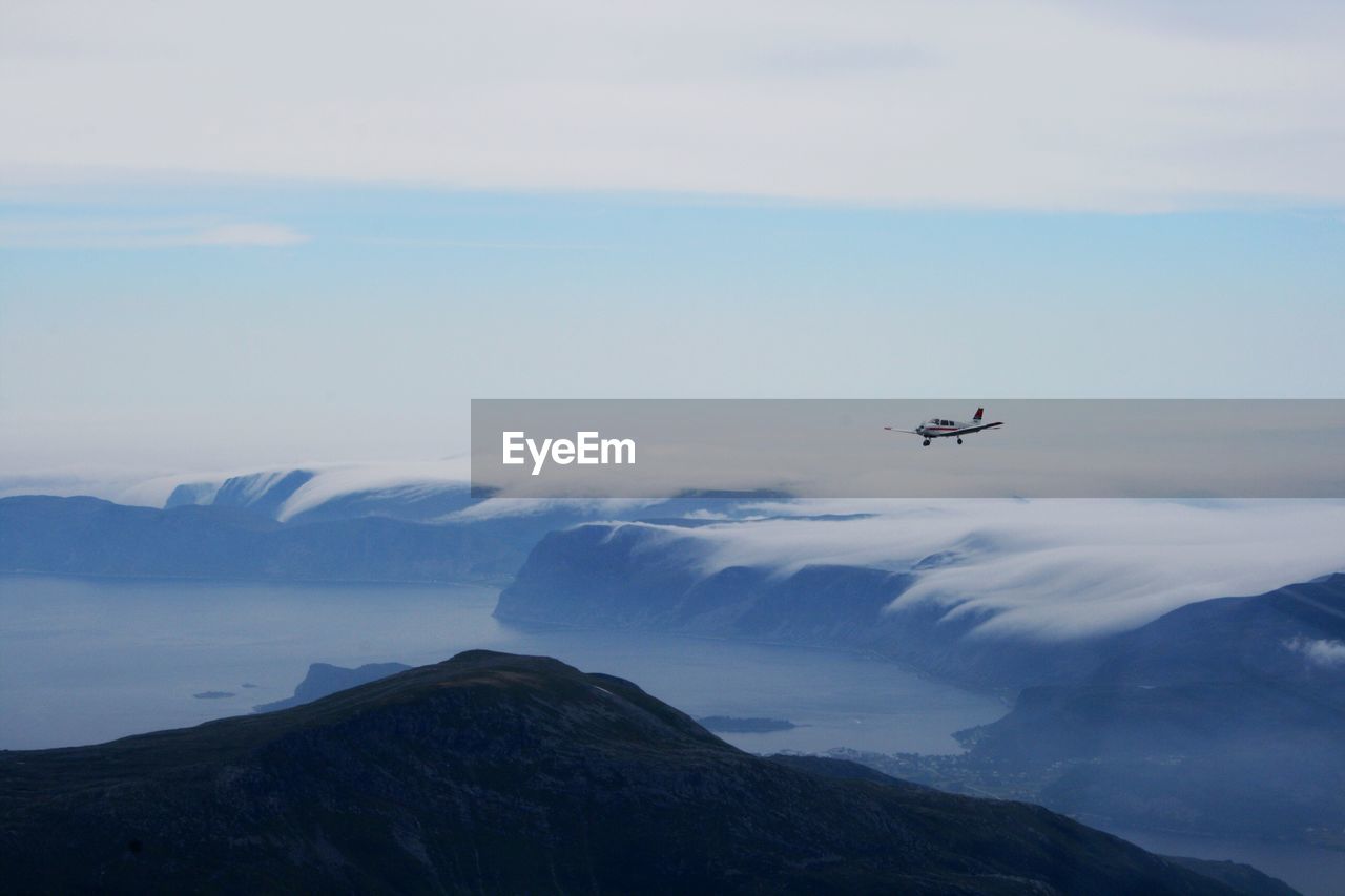 Aerial view of airplane flying over mountains