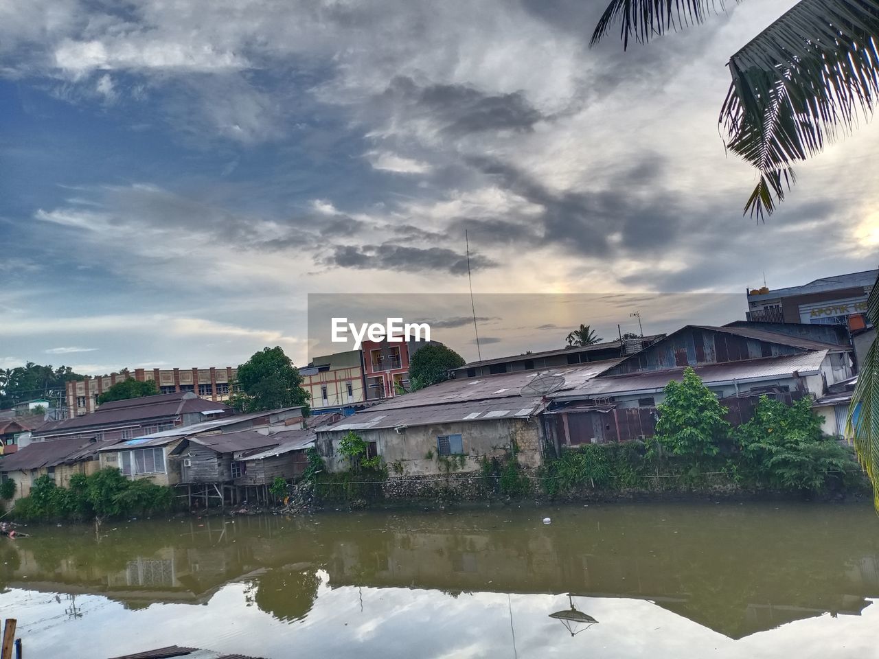 RIVER BY BUILDINGS AGAINST SKY