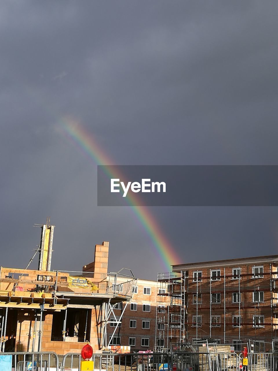 LOW ANGLE VIEW OF RAINBOW OVER BUILDINGS IN CITY