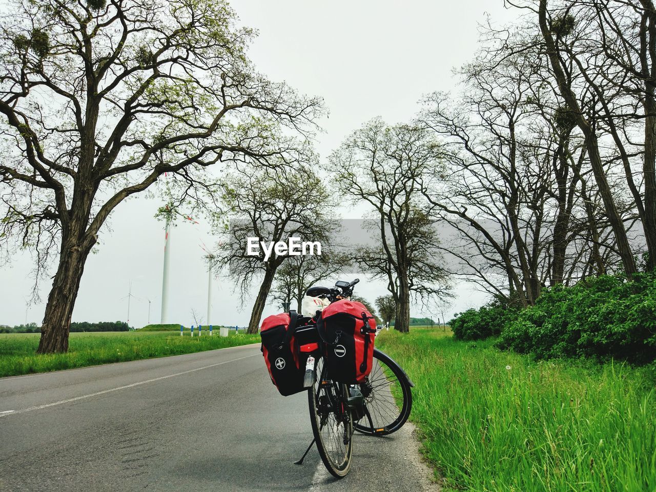 Bicycle on road amidst grassy field against clear sky