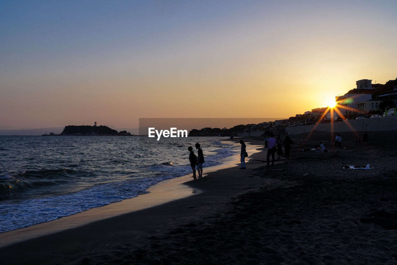 PEOPLE AT BEACH DURING SUNSET