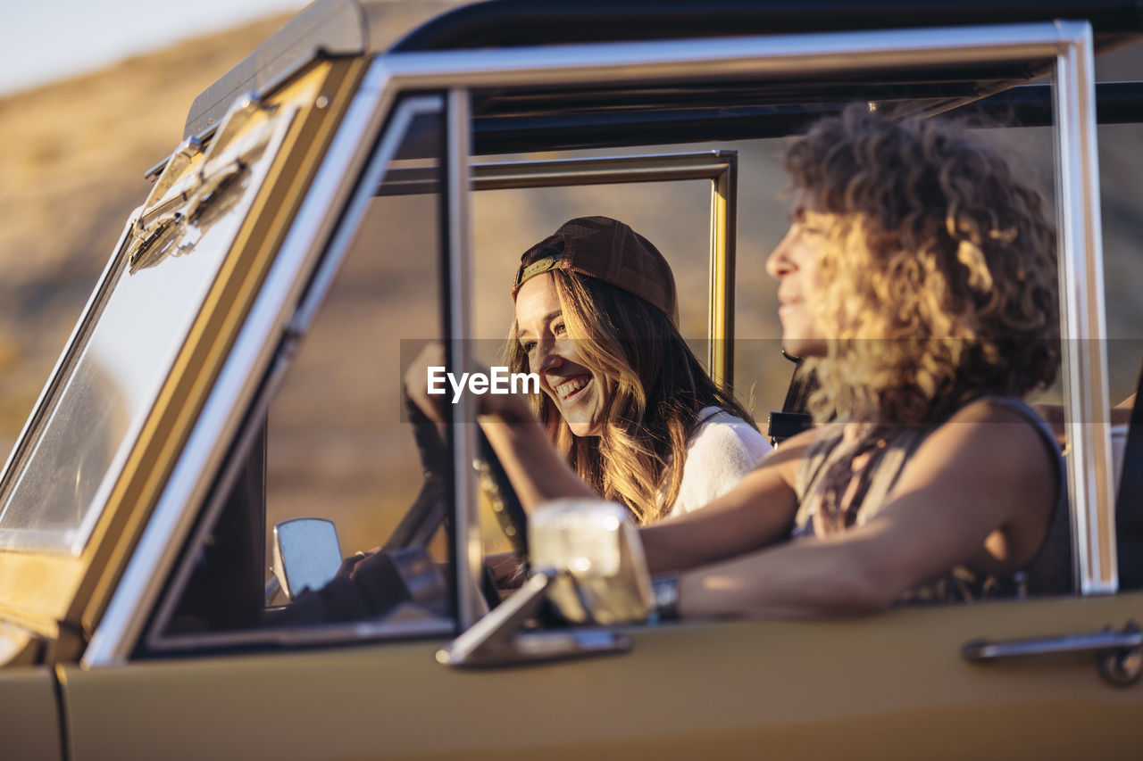 Happy female friends in off-road vehicle