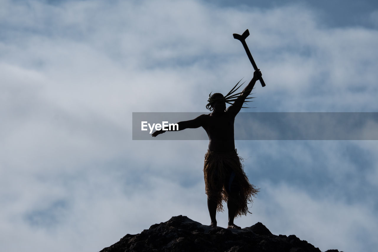 LOW ANGLE VIEW OF MAN STANDING ON TOP OF SKY