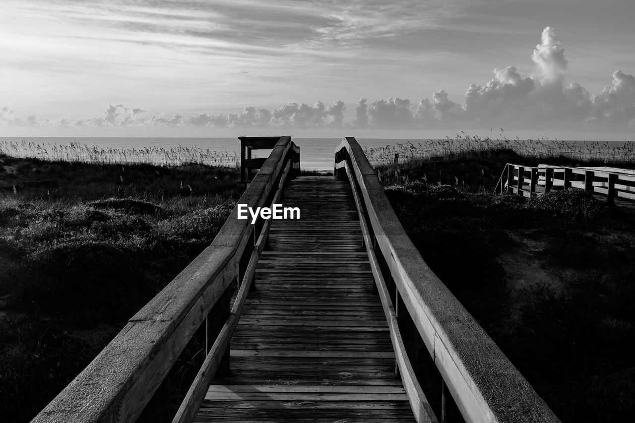 Wooden pier leading to sea