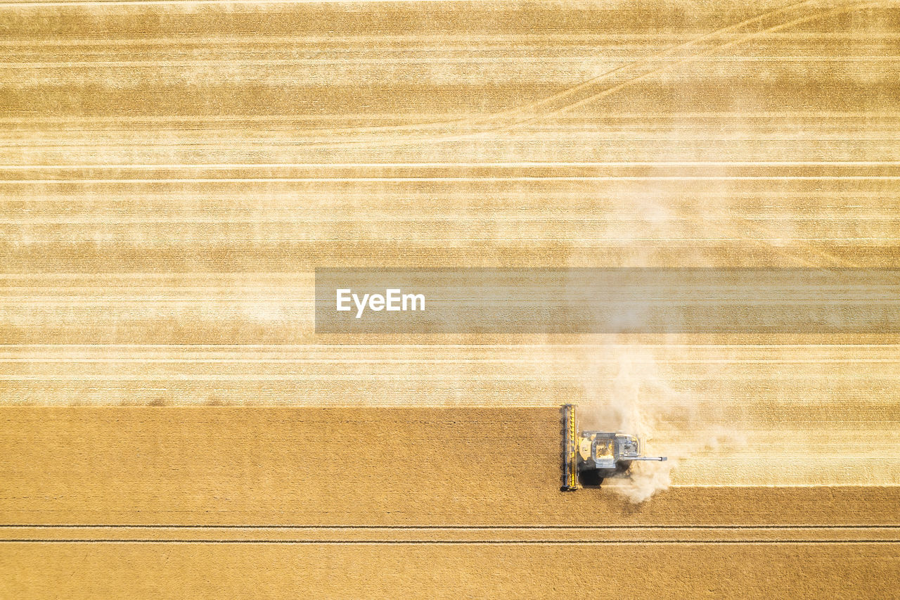 Aerial view of combine harvester in vast wheat field