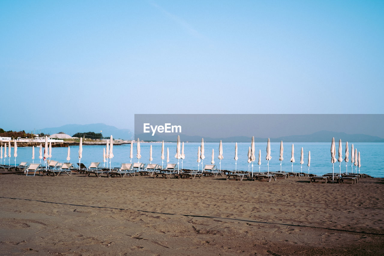 SAILBOATS ON BEACH AGAINST CLEAR SKY