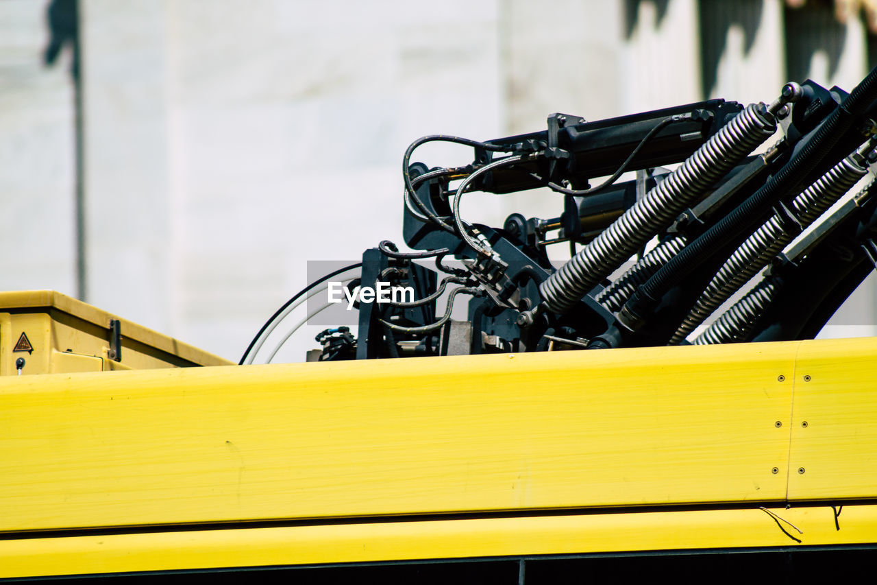 CLOSE-UP OF YELLOW BICYCLE ON METAL WALL