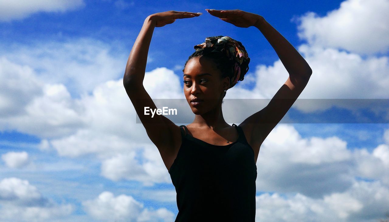 Low angle view of woman standing against sky