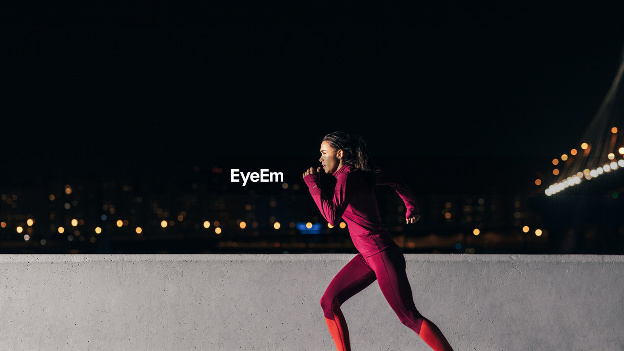 Young female jogger exercising in the evening. woman running at embankment.	