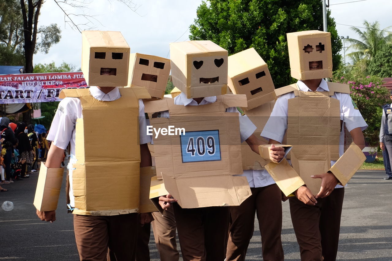 Men wearing cardboard costumes on road