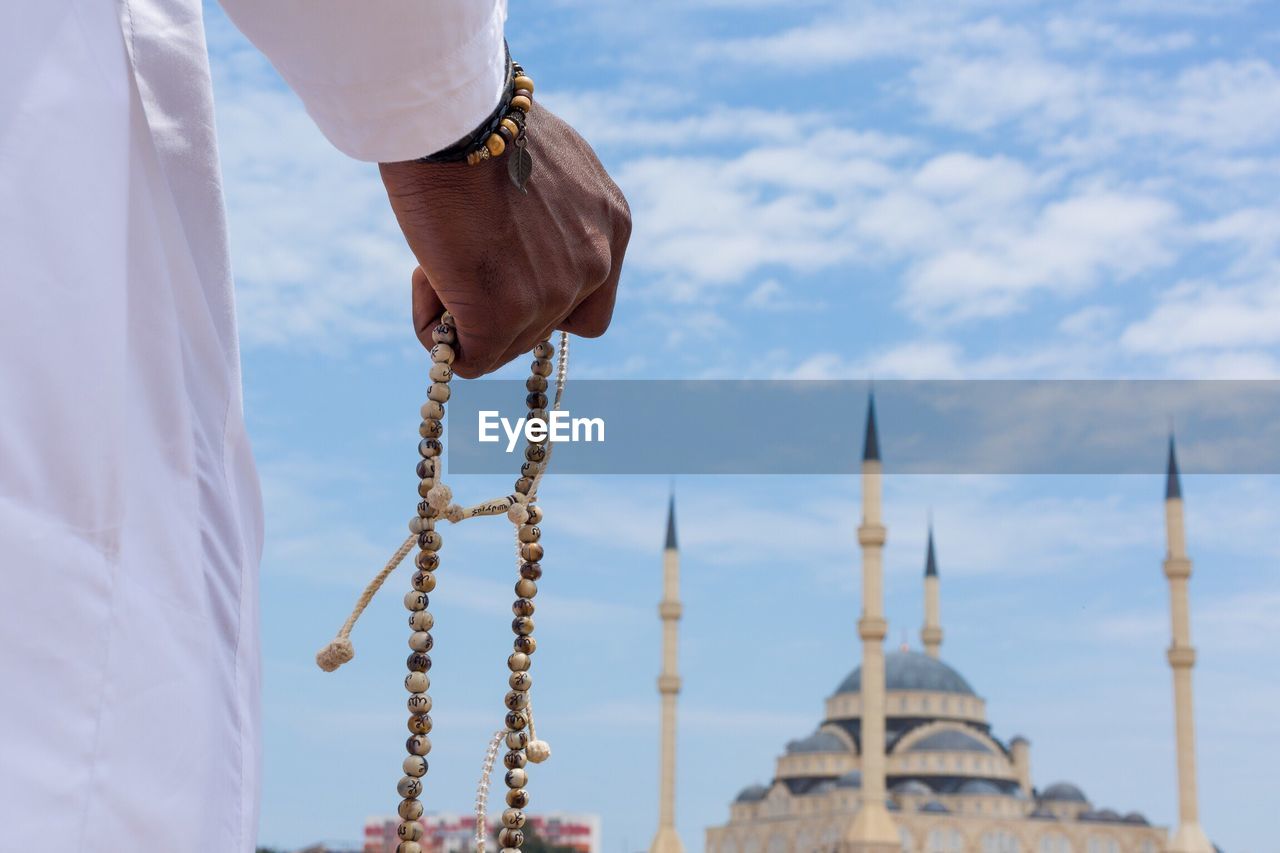 Close-up of hands holding religious beads