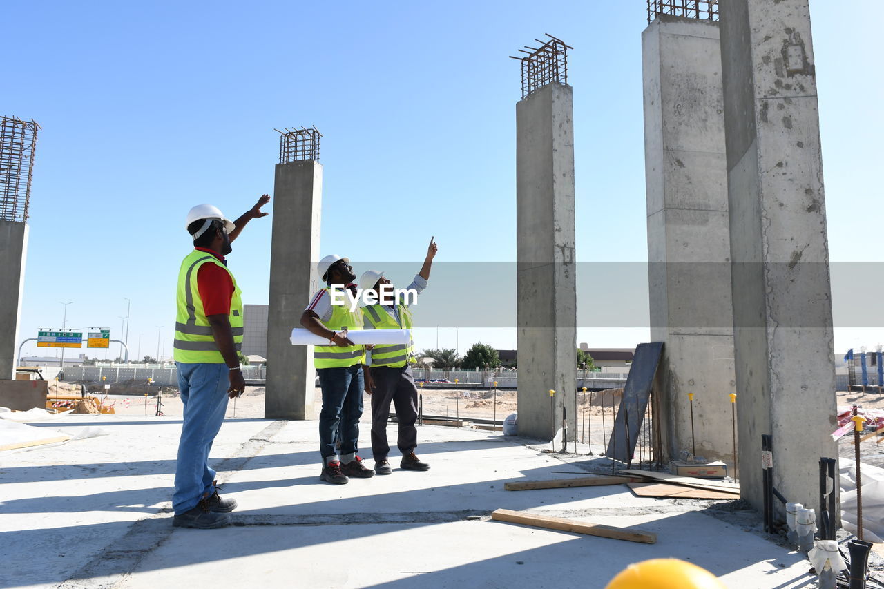 Full length of engineers working at construction site