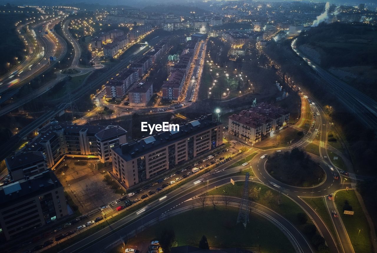 AERIAL VIEW OF ILLUMINATED CITY BUILDINGS AT NIGHT