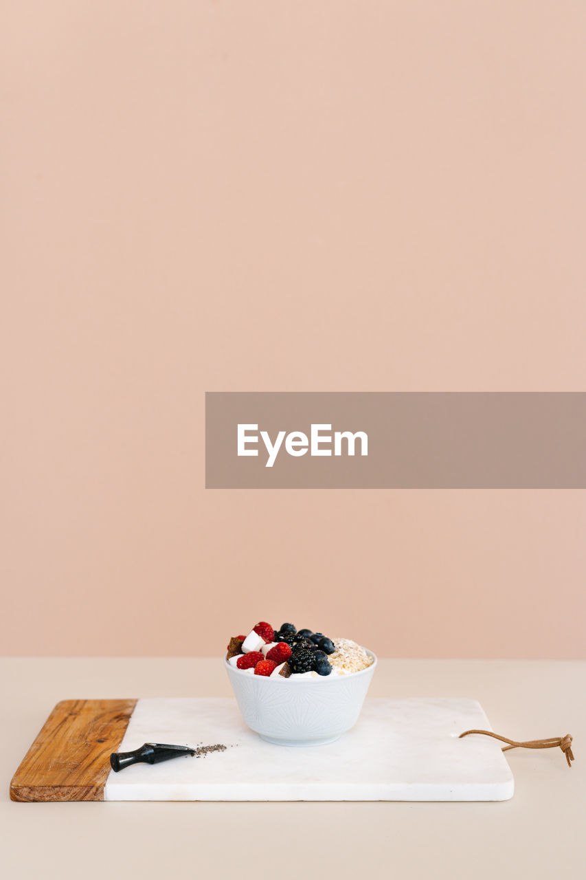 High angle of nutritious bowl with muesli and various berries in bowl placed on table for breakfast in morning