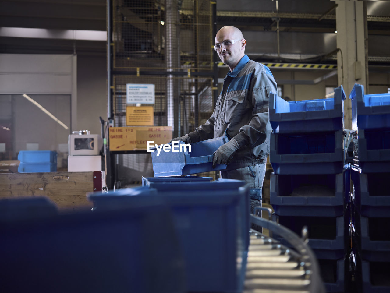 Worker putting boxes on conveyor belt