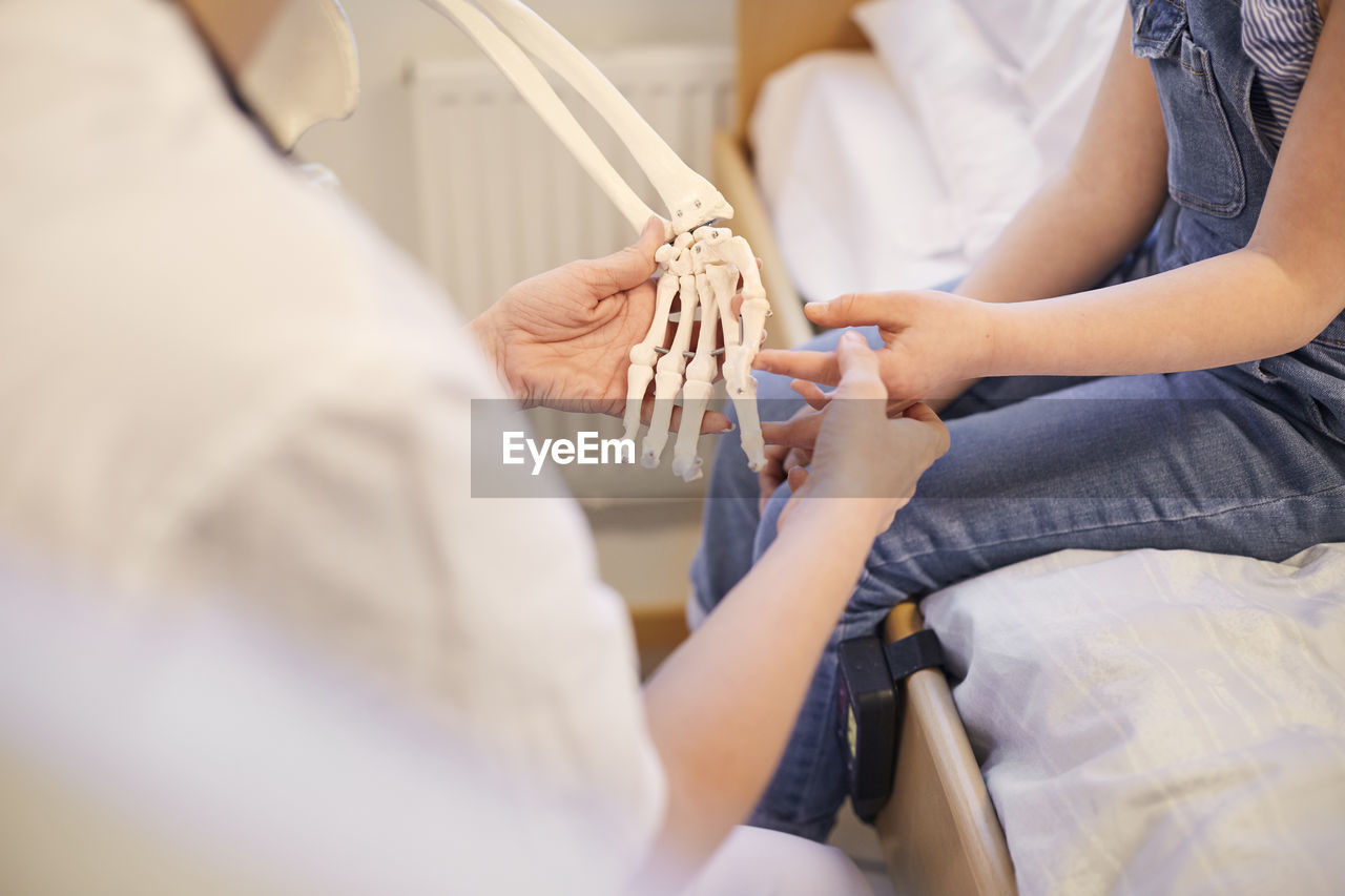 Female doctor examining girls hands