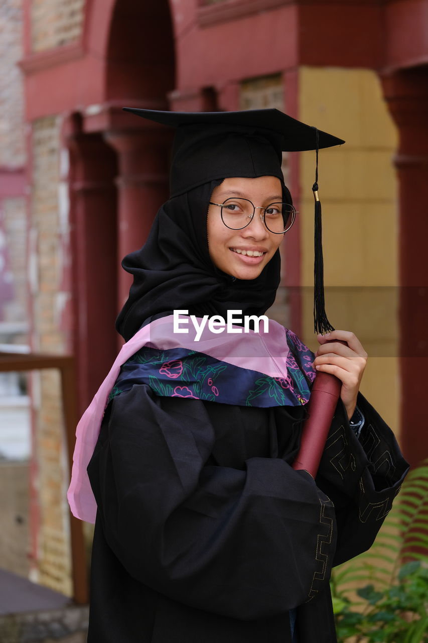 Portrait of woman looking away with convocation suit during her graduation