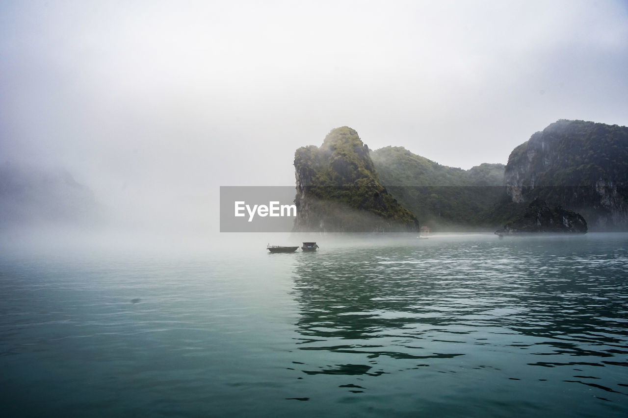 Scenic view of sea and mountains against sky