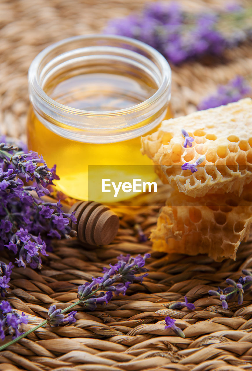 Glass of honey, honeycomb and lavender flowers