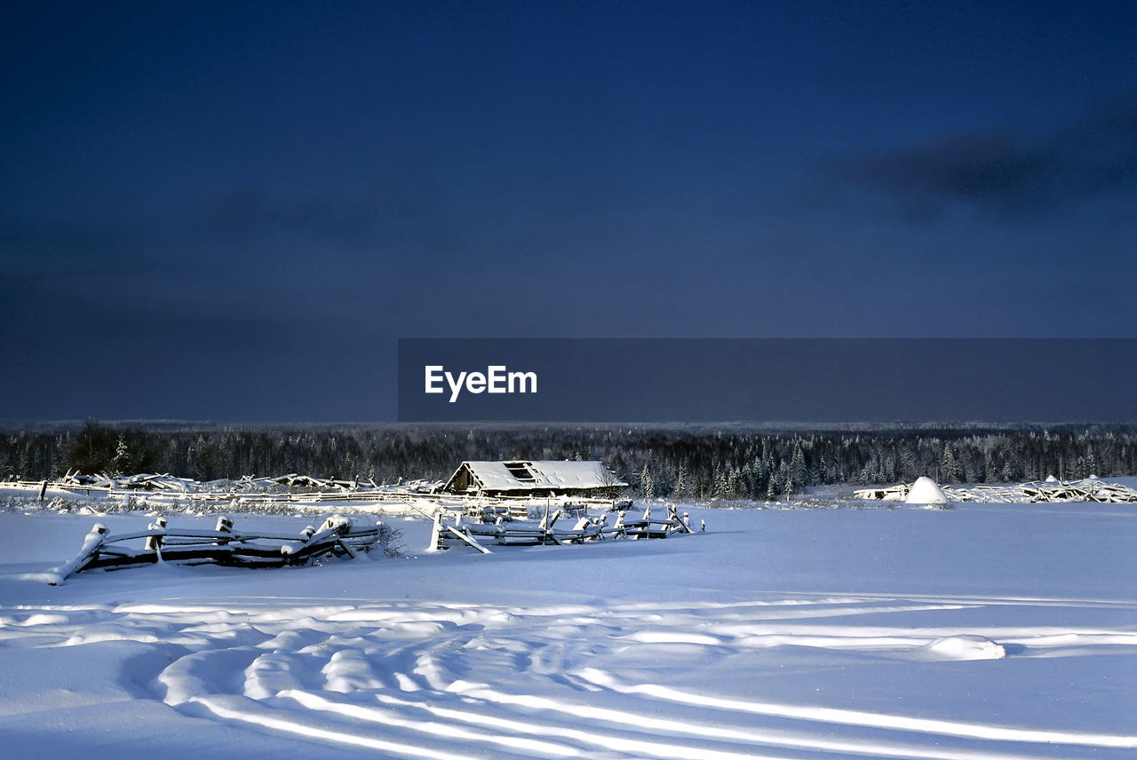 Scenic view of snow covered field against sky