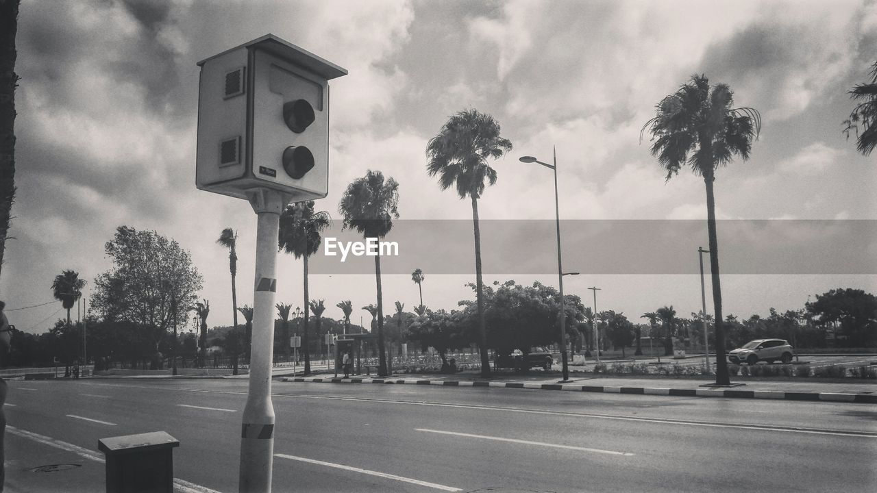 ROAD SIGN BY STREET AGAINST SKY