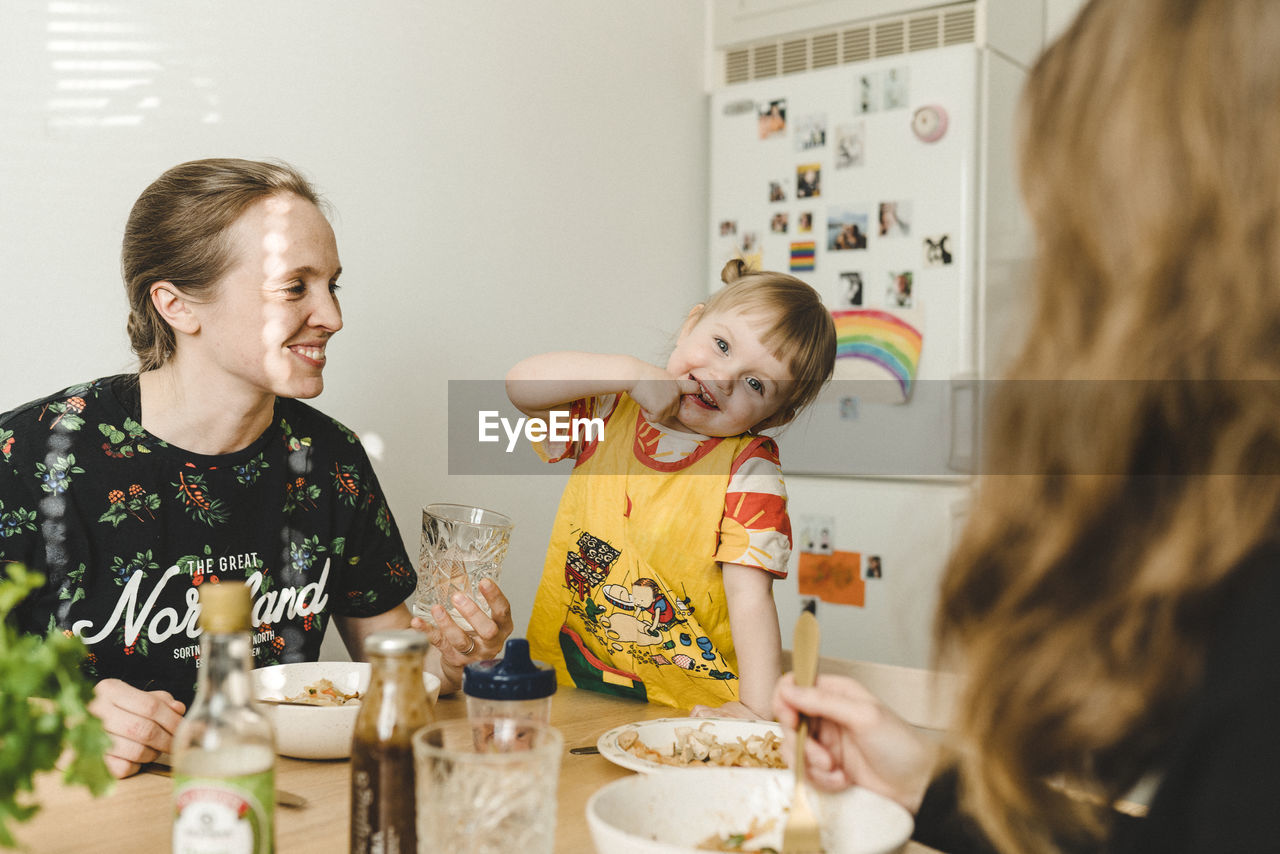 Mother with daughter sitting at table