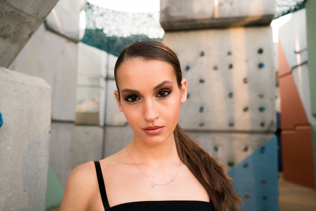 Portrait of woman standing against wall