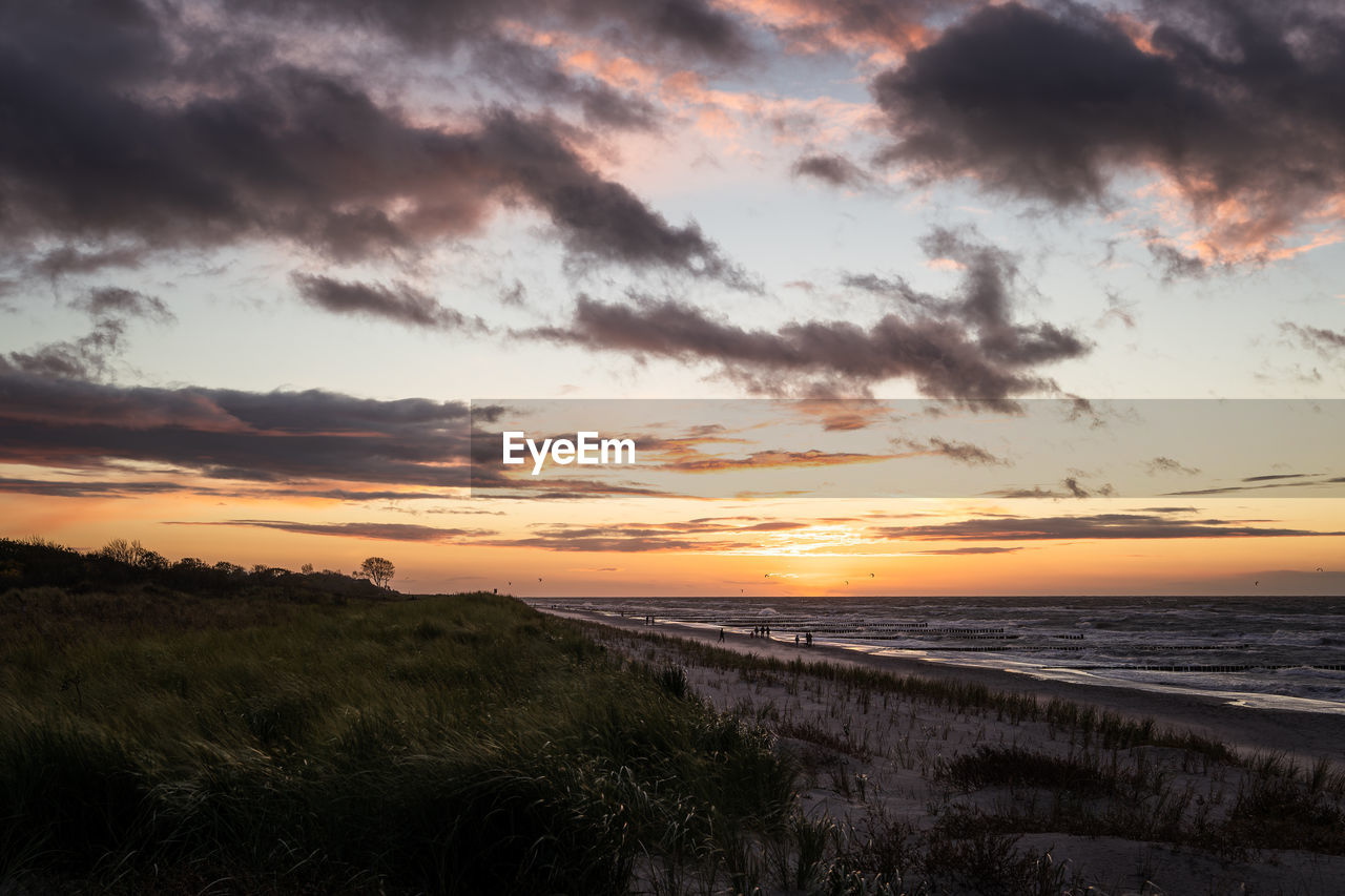 scenic view of sea against cloudy sky during sunset