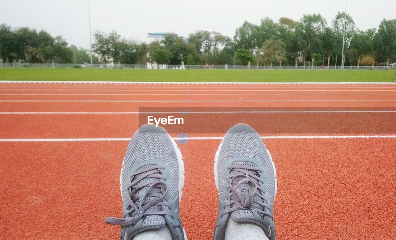 Low section of person wearing shoes on running track