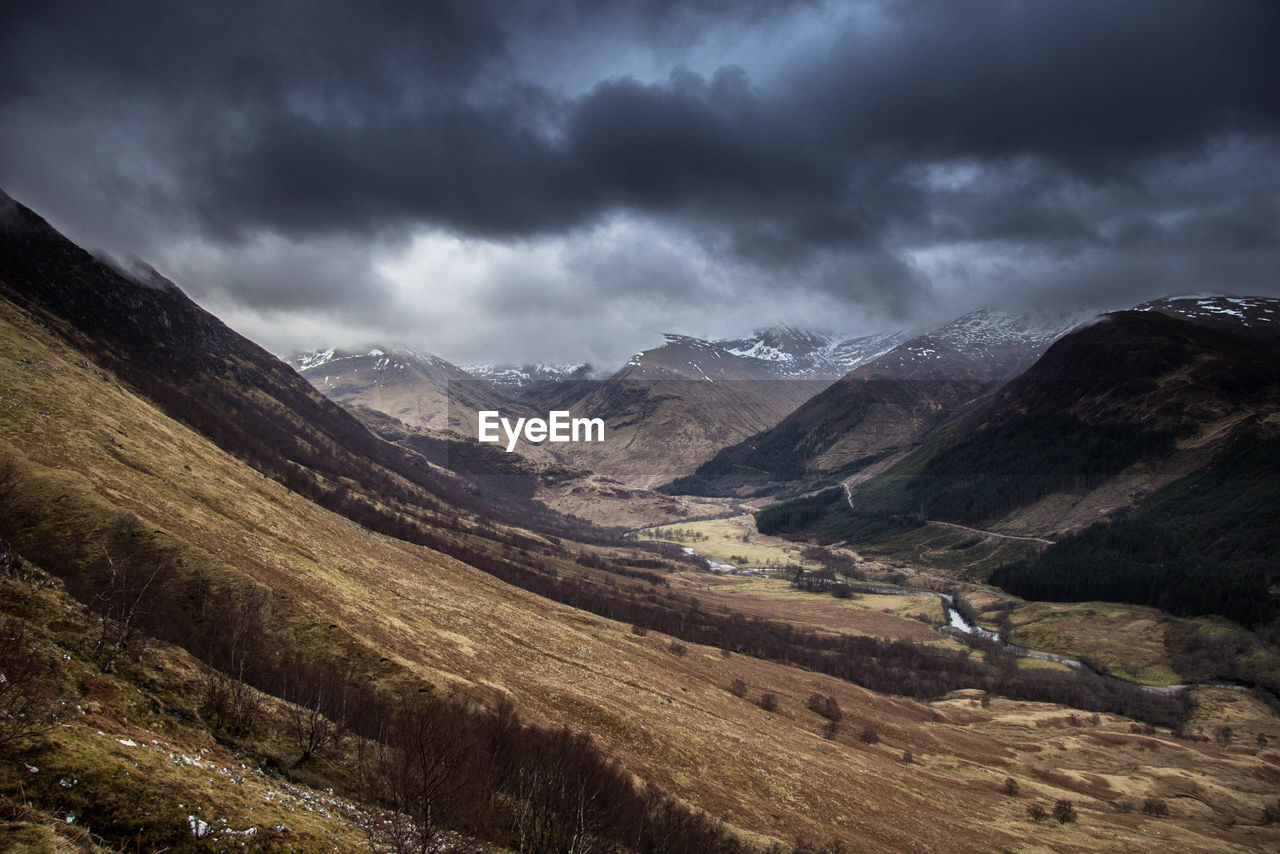 Scenic view of mountains against cloudy sky