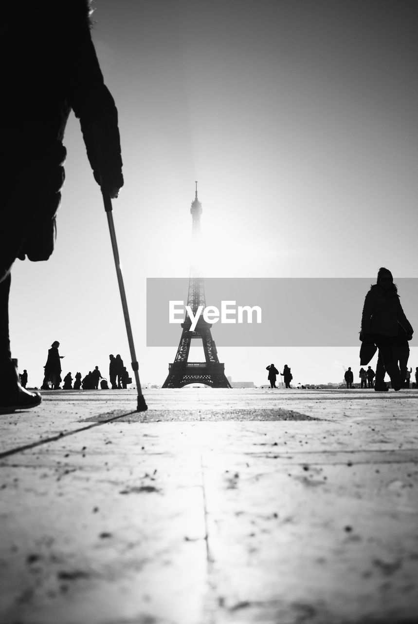 Surface level view of silhouette people with eiffel tower in background against clear sky