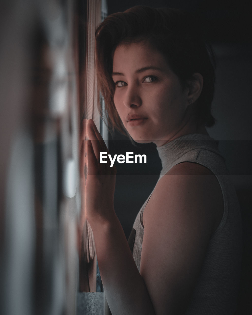 Portrait of young woman against wall at home