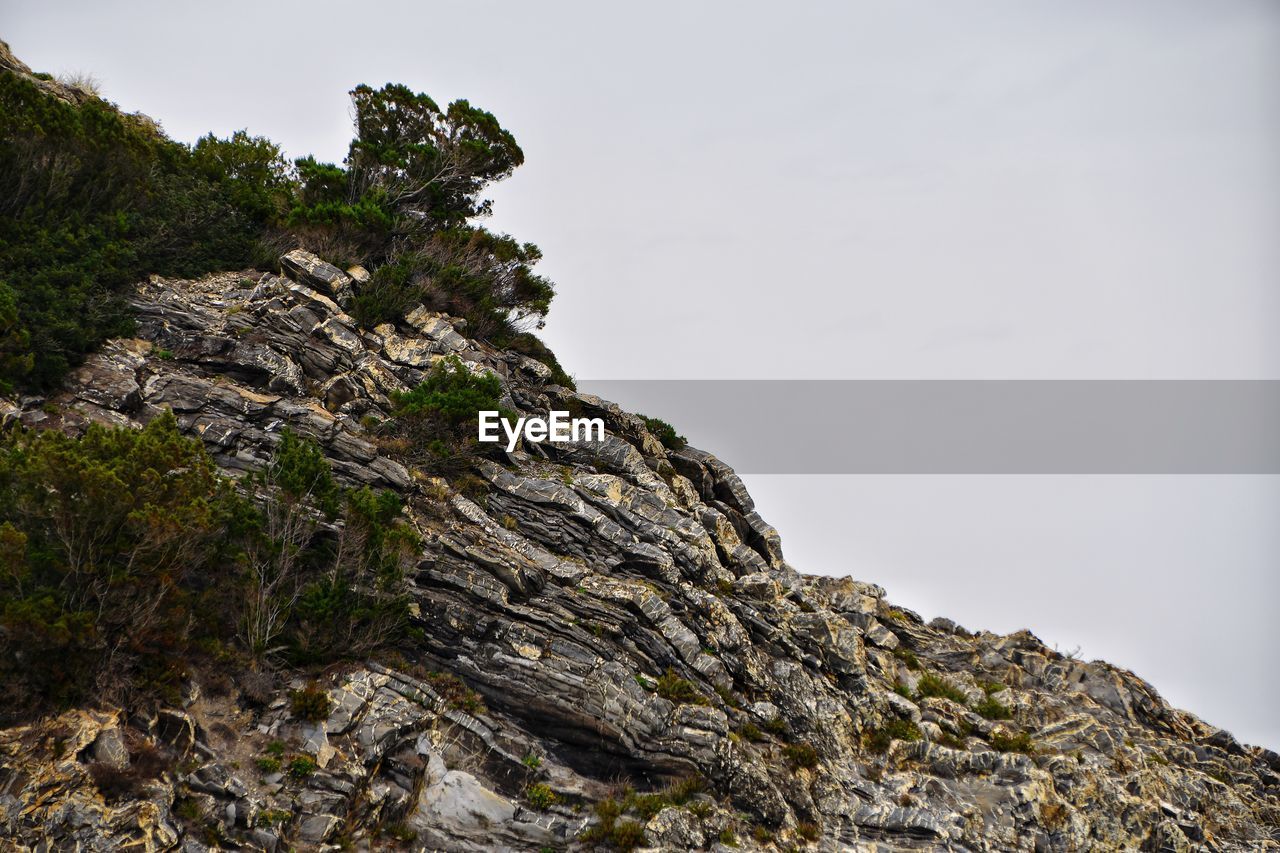 Low angle view of rock formation on mountain against sky