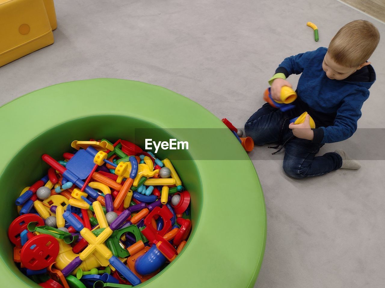 childhood, toy, high angle view, men, multi colored, child, full length, toddler, playground, indoors, one person, baby, person, sitting, footwear, directly above, occupation, adult, preschool, crouching