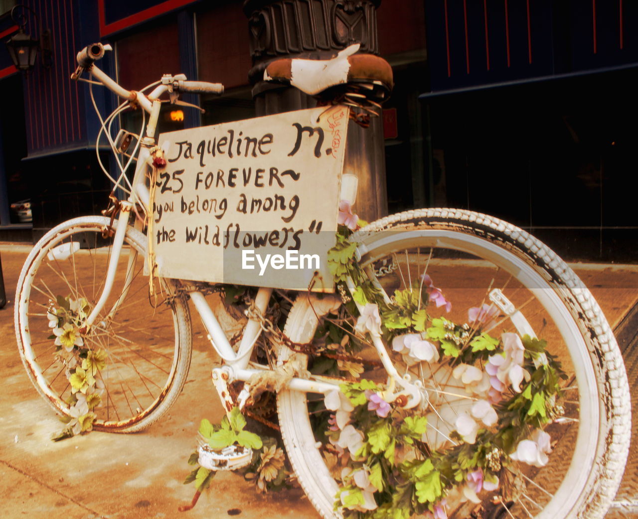 Abandoned bicycle with flowers and sign