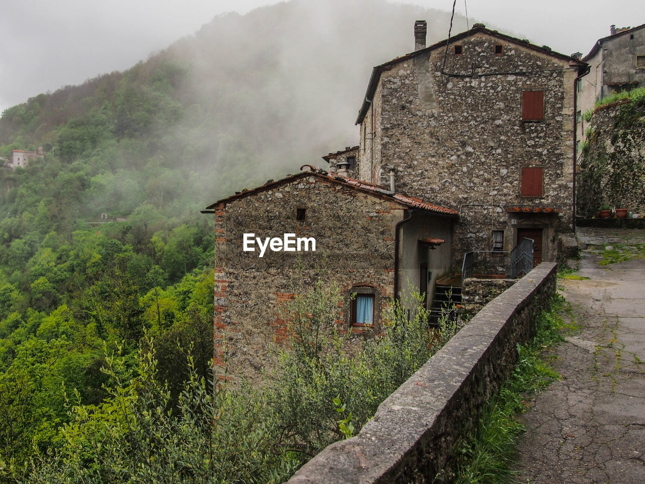 Old building by mountain against sky